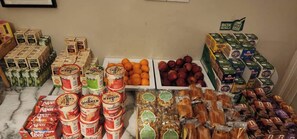 Diversos productos alimenticios, incluyendo conservas, frutas y verduras frescas, y snacks empaquetados.