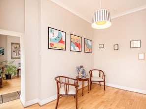 A room with wooden flooring, a dining table with chairs, and framed artwork on the walls. - The Regency, Clifton Bristol (Bristol)