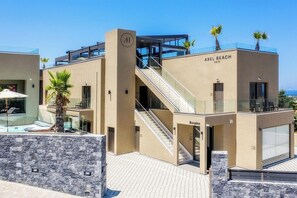 Un hotel moderno con recepción, escalera y zona de piscina.