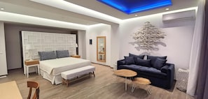 Un dormitorio moderno con cama, banco, sofá y un adorno en la pared.