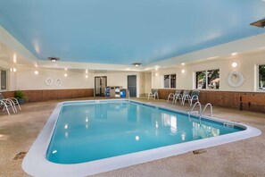 An indoor swimming pool with clear water, surrounded by lounge chairs and a wooden wall. - Saranac Lake (Saranac Lake)