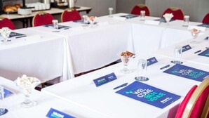 A conference room with tables set for a meeting, name cards, and a buffet area in the background. - Campanile Washington Newcastle-upon-tyne (Washington)