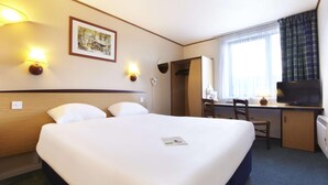 A hotel room with a large bed, a desk with a chair, a television, and a window with curtains. - Campanile Washington Newcastle-upon-tyne (Washington)