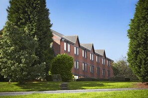 A multi-story brick building with a symmetrical facade, large windows, and a central entrance. - Campanile Washington Newcastle-upon-tyne (Washington)