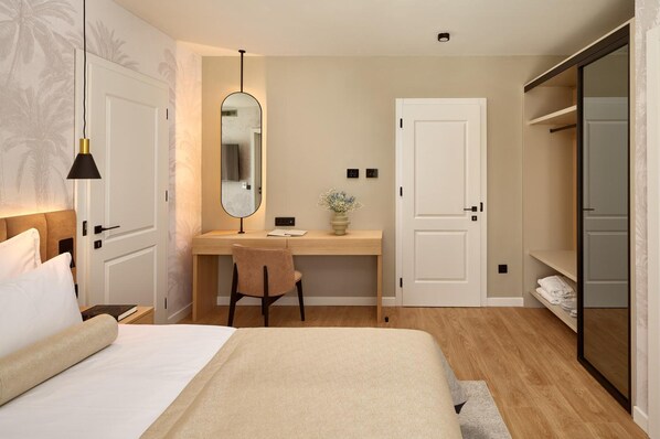 A hotel room with a bed, a desk with a chair, a wardrobe, and a mirror. - Hotel Moeesy Blue Green Oasis Ex Croatia Hotel Hvar (Hvar)