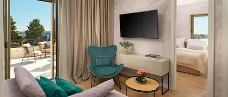 A modern hotel room with a balcony, a teal armchair, a small round table with a fruit bowl, a flat-screen TV mounted on the wall, and a bed with a white duvet.