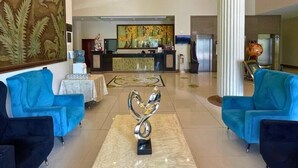 A lobby with a reception desk, blue armchairs, a chandelier, and a large painting. - Kingdom Hotel Lima (Lima)