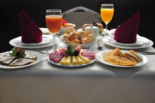 A table set with various breakfast items including pastries, a salad, and a plate of eggs. - Kingdom Hotel Lima (Lima)