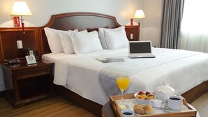 A hotel room with a bed, a laptop, a tray with breakfast items, and a bedside table with a lamp. - Kingdom Hotel Lima (Lima)
