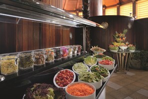 Un bufé con diversos alimentos y una decoración de frutas.
