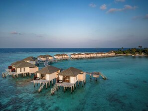 Overwater bungalows connected by walkways over turquoise water. - NH Collection Maldives Havodda Resort (Havodda)