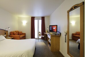 A hotel room with a bed, a desk with a computer, a chair, and a large mirror. - Preston North (Preston)