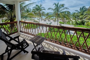 A balcony with a view of a beach, palm trees, and a clear sky. - Selina Tulum (Tulum)