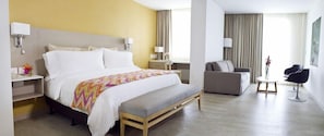 A hotel room with a bed, bedside tables, a sofa, a chair, and a small table. - Mercure Santa Marta Emile (Santa Marta)
