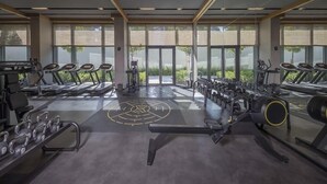 Un gimnàs amb cintes de córrer, aparells de musculació i peses lliures.