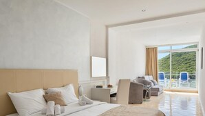 A hotel room with a bed, a desk, and a view of the outdoors. - Maslinica Hedera Hotel (Labin)