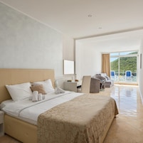 Quarto de hotel com cama, escrivaninha e vista para o exterior.