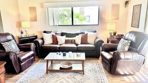 Ein Wohnzimmer mit Ledersofas, einem Couchtisch und einem Teppich.