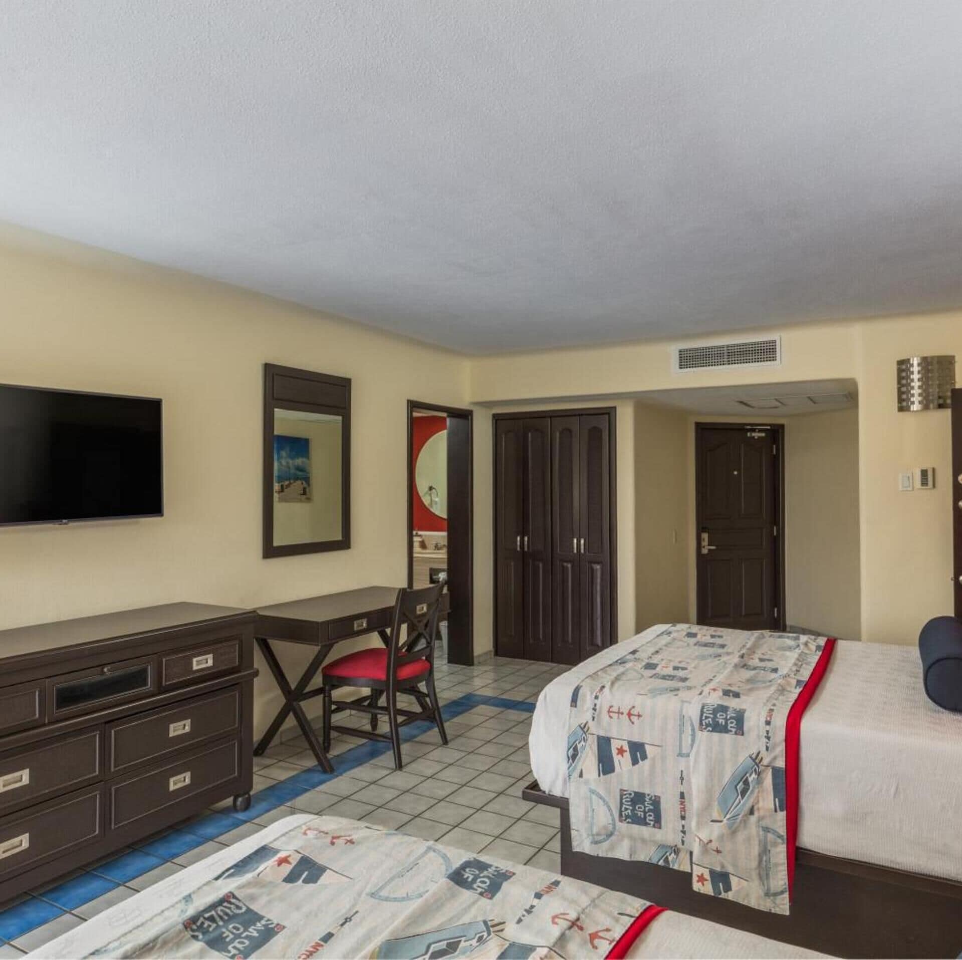 Une chambre à coucher comprenant un lit, un bureau, une chaise, une télévision et une armoire.