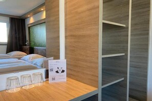 A hotel room with a bed, a wooden wall, and a QR code on the table. - Smart Hotel Schonbrunn (Vienna)