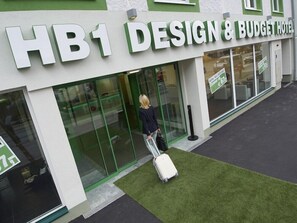 L’entrée d’un hôtel, avec une enseigne indiquant : « HB1, hôtel design et économique ».