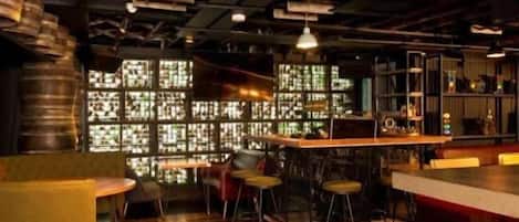 A bar area with stools, a counter, and a large window with a grid pattern.