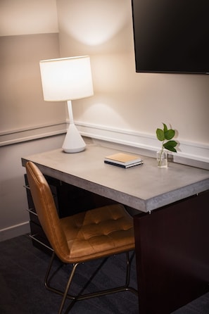 A desk with a lamp, a notebook, and a small plant. - Kimpton Lorien Hotel and Spa (Alexandria)