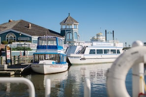 A docked boat named 'Miss Mallory' with 'Admiral Tip' written on its side, a building with a sign reading 'Chart House,' and a clear blue sky. - Kimpton Lorien Hotel and Spa (Alexandria)