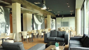 Un intérieur moderne avec des canapés, des tables et des chaises disposés de manière à créer un espace à la fois convivial pour les repas et propice à la détente.