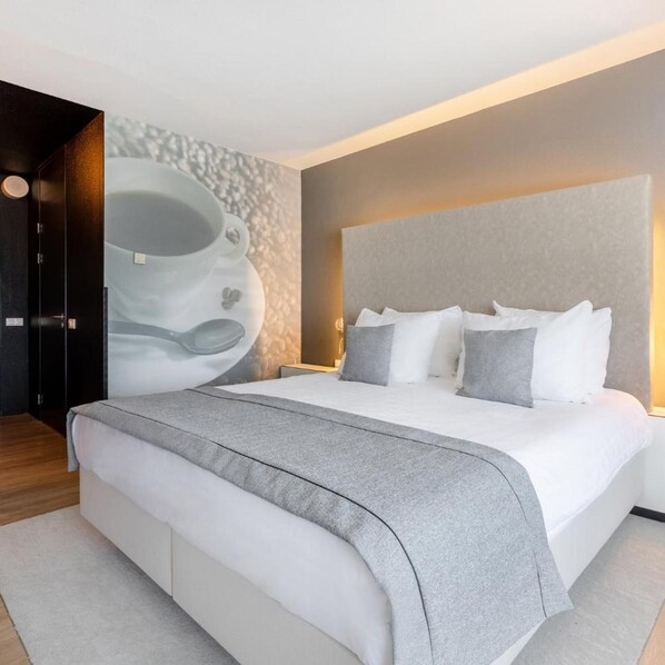 A modern bedroom with a large bed, a headboard, and a wall-mounted artwork. - Select Hotel Apple Park Maastricht (Maastricht)