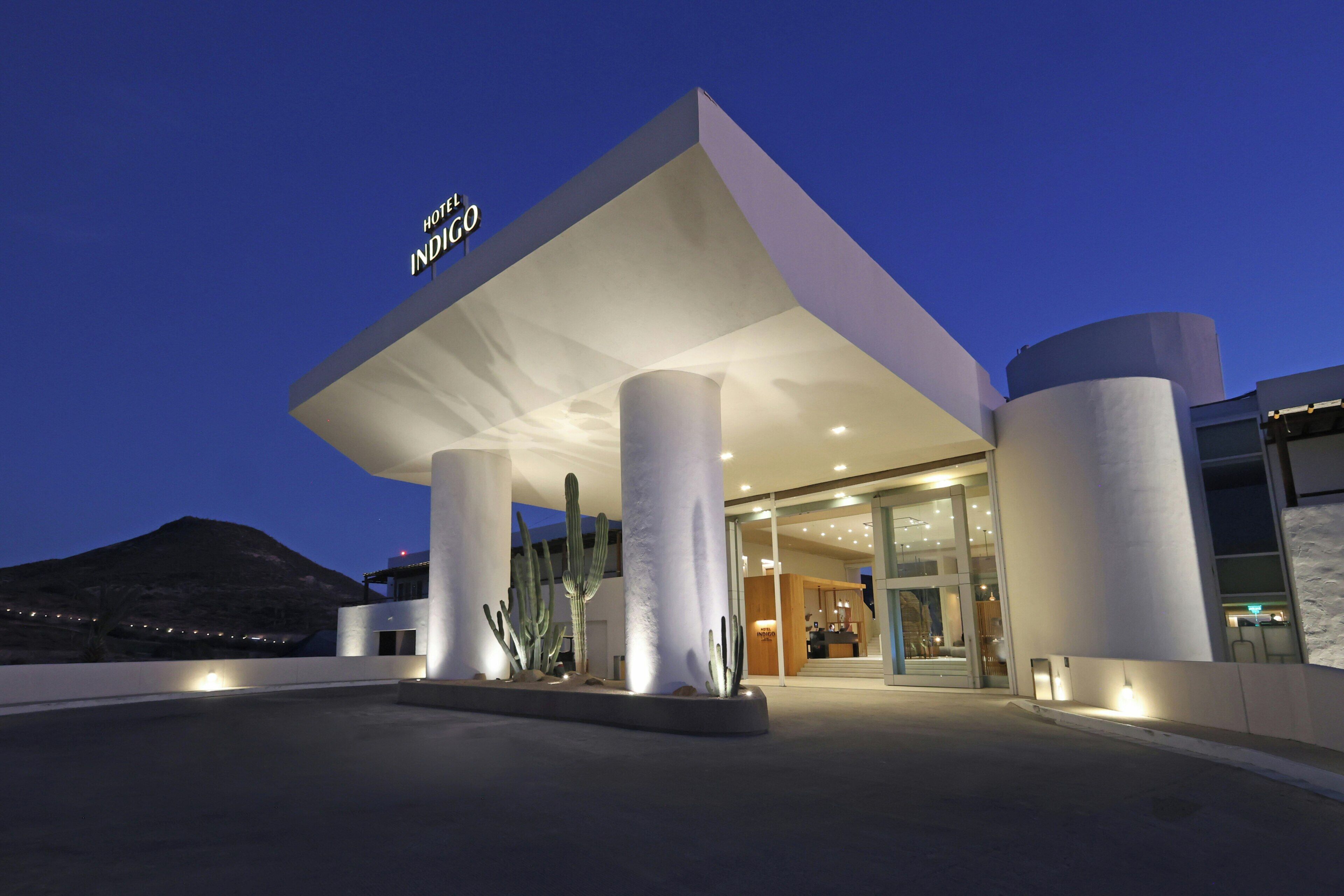 Una entrada de hotel moderna con techo plano y amplias columnas.