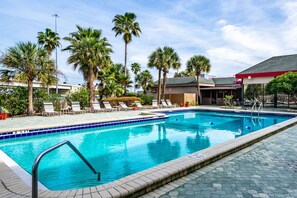 A swimming pool with lounge chairs and palm trees. - Best Western Premier Lakeland North (Lakeland)