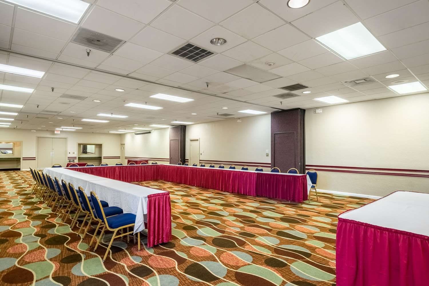 A conference room with a long table, chairs, and a patterned carpet.
