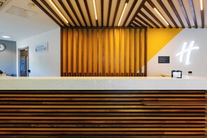 A reception desk with a wooden slat design, a clock, and a sign for 'BOLDON LEISURE.' - Clarion Hotel Newcastle South Boldon EN (Boldon Colliery)