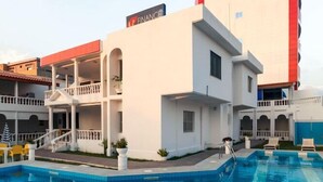 A hotel with a swimming pool, a balcony, and a sign indicating it is a hotel. - Hotel Bkbg (Lomé)
