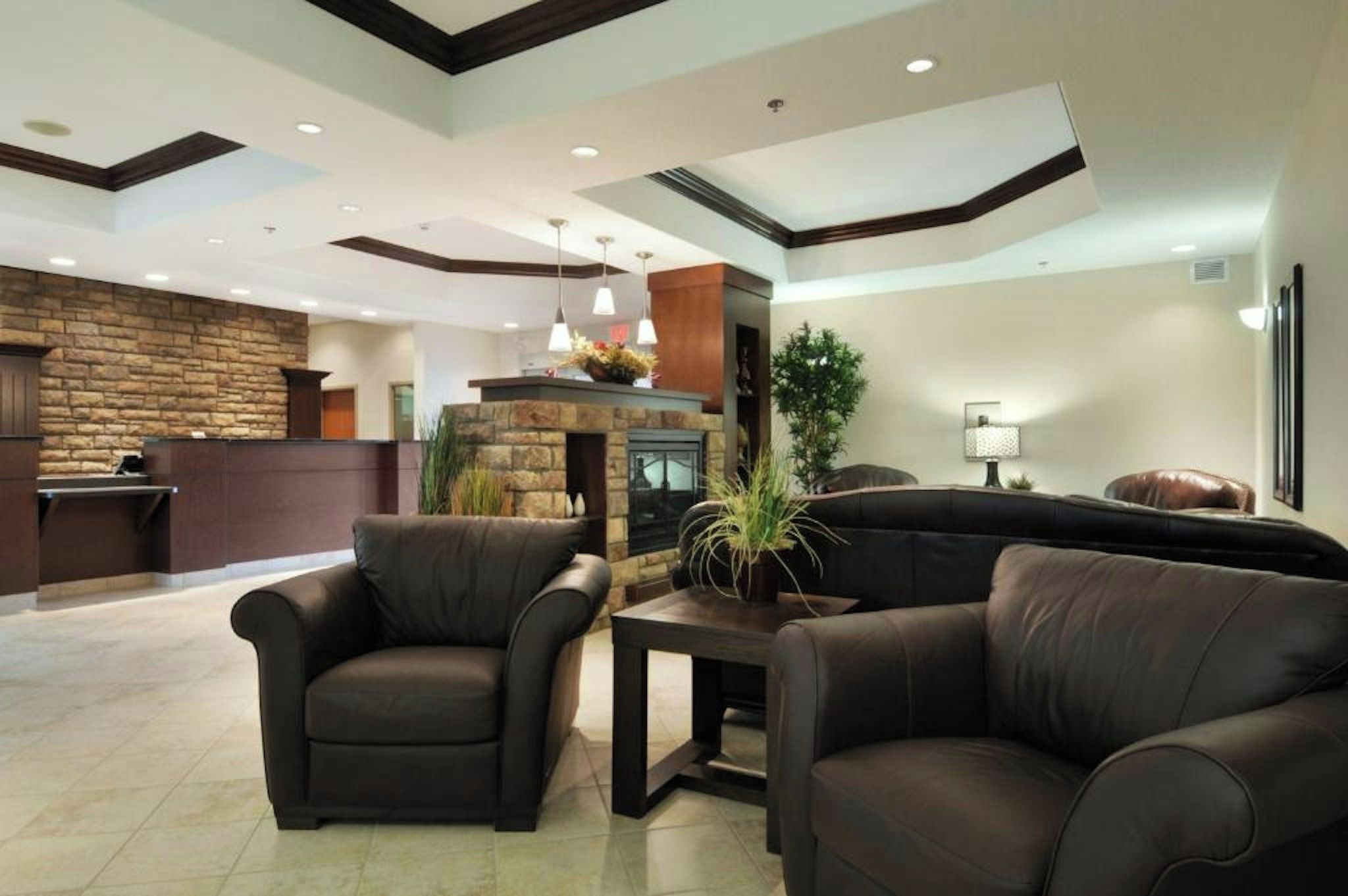A lobby with a stone fireplace, leather sofas, and a reception desk.