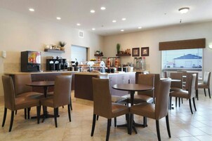 A restaurant with booths and tables, a coffee station, and a view of the outside.