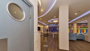 A modern hotel lobby with a bar area, seating, and a colorful wall mural. - Selenay Hotel Istanbul (Istanbul)