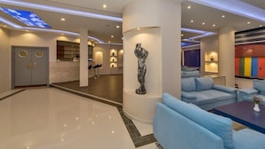 A modern lobby with a central column, a reception desk, and a seating area with blue sofas. - Selenay Hotel Istanbul (Istanbul)