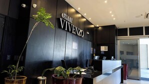 A reception desk with a sign reading 'GRAN VIVENZO' and potted plants. - Hotel Gran Vivenzo Belo Horizonte (Belo Horizonte)