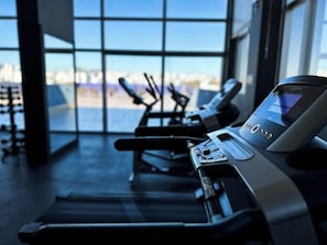 A gym with cardio machines and a large window with a city view. - Hotel Gran Vivenzo Belo Horizonte (Belo Horizonte)