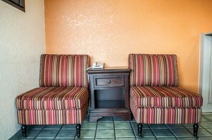 A corner seating area with two upholstered chairs and a small table with drawers. - Rodeway Inn Albuquerque NM (Albuquerque)