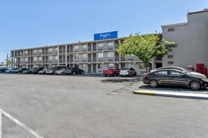 A multi-story motel with a row of parking spaces in front. - Rodeway Inn Albuquerque NM (Albuquerque)