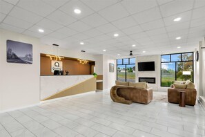 A spacious lobby with a reception desk, seating area, and large windows offering a view of the outdoors. - Quality Inn & Suites Wytheville (Wytheville)