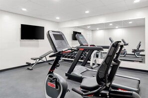 A gym with exercise equipment, a TV mounted on the wall, and a mirror reflecting the equipment. - Quality Inn & Suites Wytheville (Wytheville)