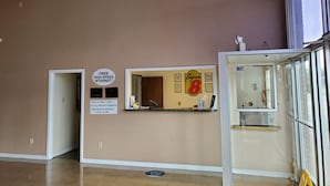A hotel reception area with a sign offering free high-speed internet, a check-out time notice, and a Super 8 logo. - Super 8 Little Rock North Airport (North Little Rock)