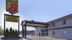 A Super 8 motel with a truck parking sign, a covered parking area, and a building with a brick facade. - Super 8 Little Rock North Airport (North Little Rock)