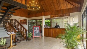 A reception area with a wooden staircase, a reception desk, and a sign that reads 'WELCOME'. - Hotel Ficus Monteverde (Monteverde)