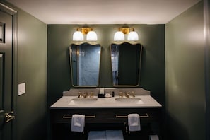 Ein Badezimmer mit zwei Waschbecken, einem Spiegel und einem Handtuchhalter.