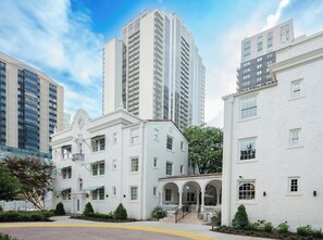 A white building with a central courtyard, large windows, and a staircase leading to an upper level. - Artmore Hotel (Atlanta)